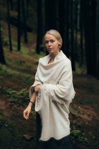 Portrait of young woman standing in forest