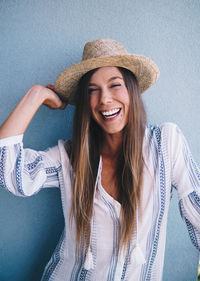 Woman wearing hat against wall