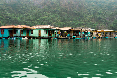 House by lake against trees