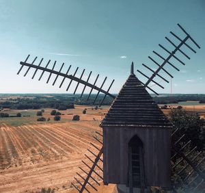 Windmill on field against sky