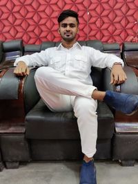 Portrait of young man sitting on sofa