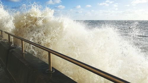 Waves splashing on railing at brighton beach