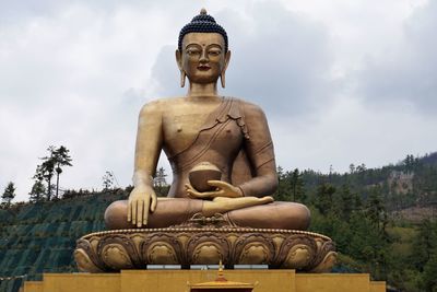 Low angle view of statue against temple against sky