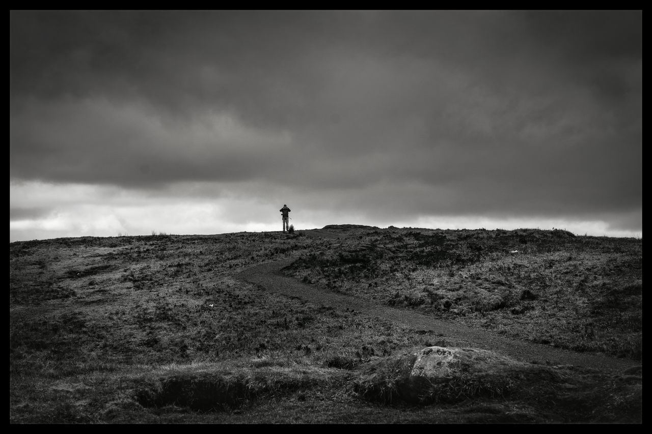 transfer print, sky, landscape, auto post production filter, field, tranquil scene, tranquility, cloud - sky, lighthouse, grass, scenics, nature, hill, guidance, one person, cloudy, cloud, horizon over land, beauty in nature, non-urban scene