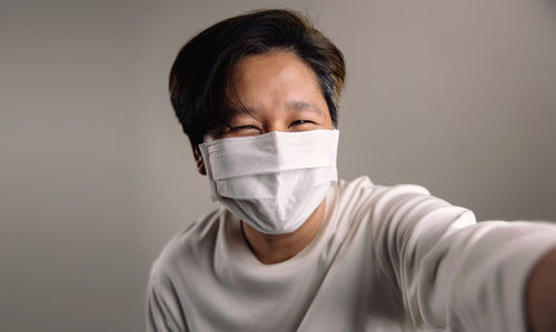 Portrait of man wearing mask against white background