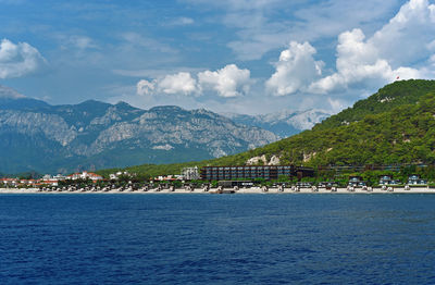 Scenic view of sea by townscape against sky