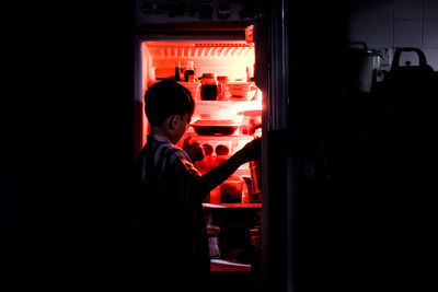 Rear view of boy looking at illuminated nightclub