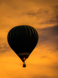 Silhouette of hot air balloon against dramatic sunset sky