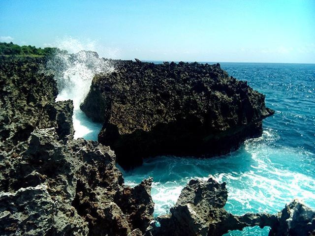 water, sea, rock formation, rock - object, beauty in nature, scenics, blue, nature, clear sky, rock, tranquil scene, horizon over water, tranquility, wave, idyllic, cliff, geology, motion, splashing, surf