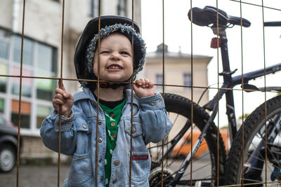 Portrait of happy boy standing against building