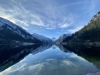 Scenic view of lake by mountains against sky