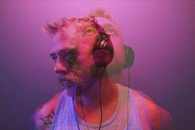 Double exposure of man listening to music