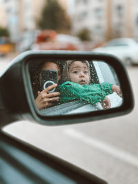 Reflection on side-view mirror of car