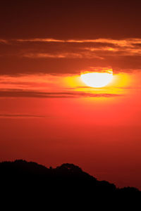 Scenic view of silhouette mountains against romantic sky at sunset