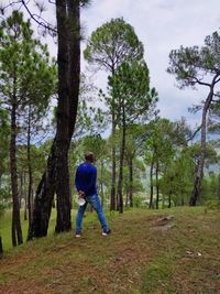Full length of man standing on field in forest