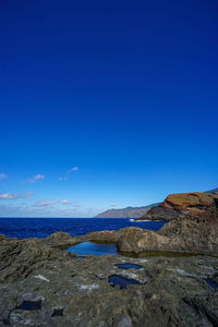 Scenic view of land against clear blue sky