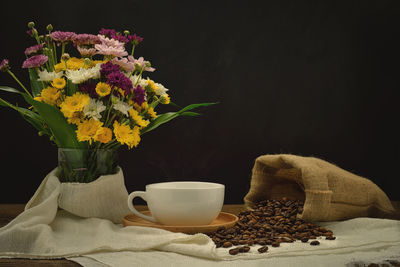 Flower vase on table against black background