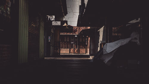 Illuminated alley amidst buildings in city at night