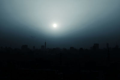 Silhouette cityscape against clear sky