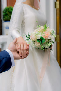 Crop newlyweds holding hands during wedding