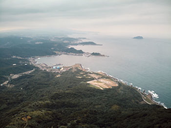 High angle view of sea and mountains against sky