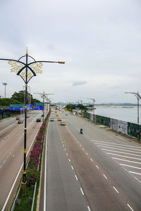 Cars on road in city against sky