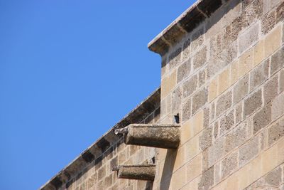 Low angle view of old building against clear blue sky