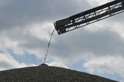 Low angle view of crane against sky