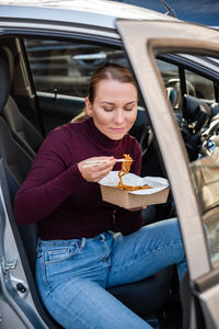Portrait of smiling woman sitting in car