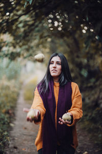 Woman juggling some pears in the field