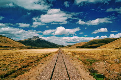 Railroad track amidst mountains against sky