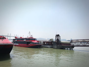 Boats moored on river against sky