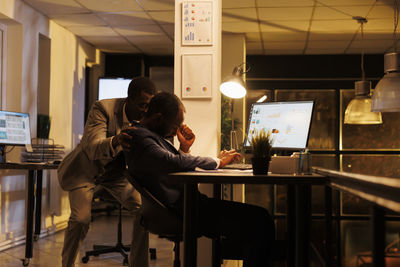 Side view of man using laptop at airport