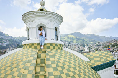 Young woman sitting on dome at cathedral of quito