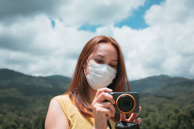 Young woman traveller using her camera