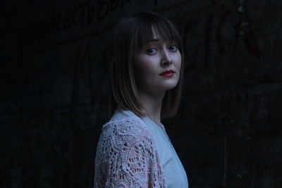 Portrait of beautiful woman standing against wall