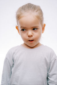 Portrait of cute boy standing against white background