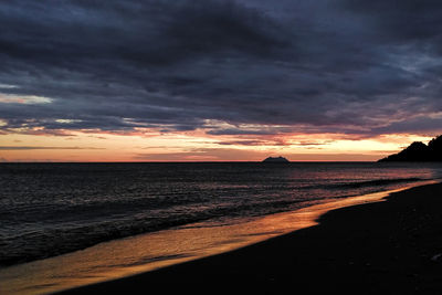 Scenic view of sea against dramatic sky during sunset
