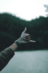 Close-up of person hand on street against sky