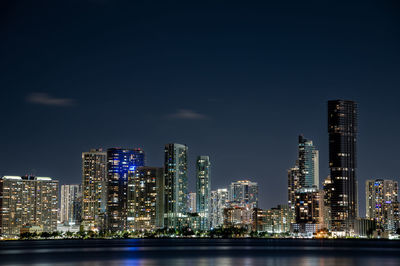 Illuminated buildings in city against sky at night