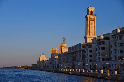 View of sea amidst buildings against sky in city