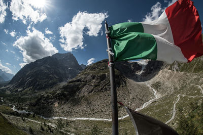 Low angle view of flag on mountain against sky