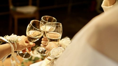 Midsection of bride holding wineglass