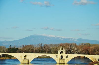 Arch bridge over lake against sky