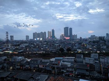 Aerial view of buildings in city against sky