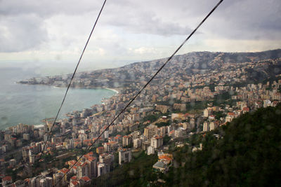 High angle view of townscape by sea against sky