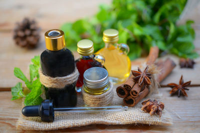 Close-up of oils with cinnamon sticks and dropper on table