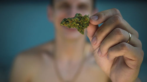 Midsection of man holding marijuana