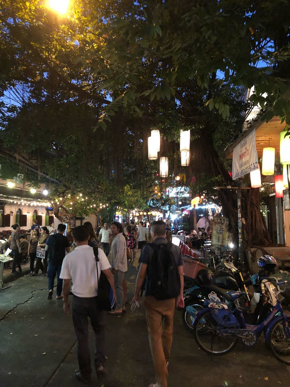 PEOPLE WALKING ON STREET IN CITY AT NIGHT