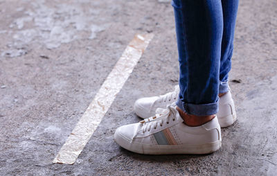 Low section of woman standing on road